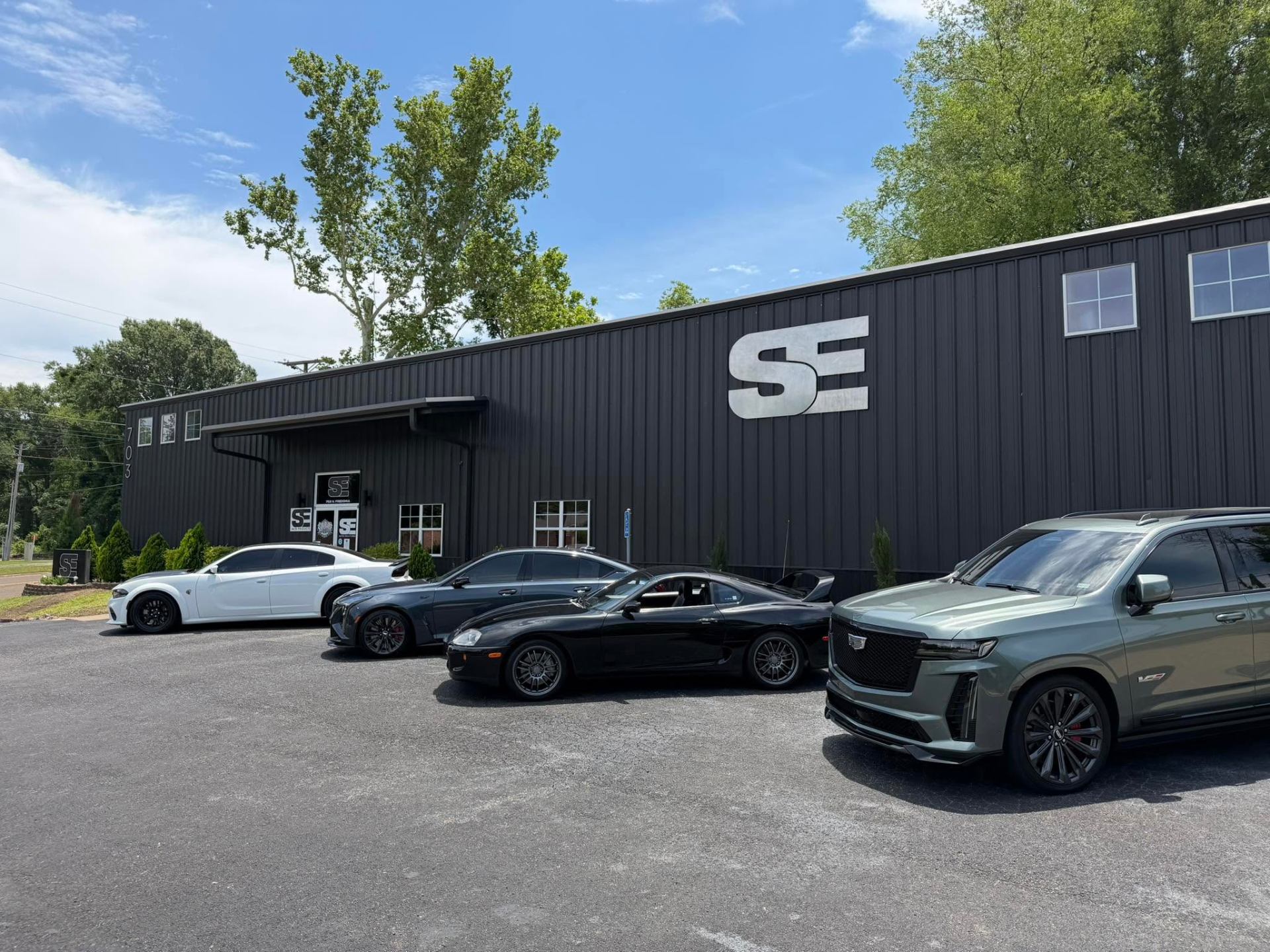 SE Auto Solutions shop front with client vehicle fleet — premium show finishes under natural light, Longview